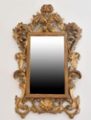 A SMALL ITALIAN FLORENTINE GILTWOOD MIRROR with scrolls. 1ft 11ins x 1ft 1ins.