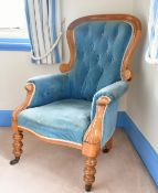 A BUTTONED BACK ARMCHAIR.