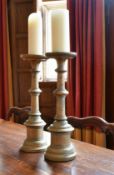A PAIR OF TURNED WOOD CANDLESTICKS, possibly Italian.1ft 6ins high.