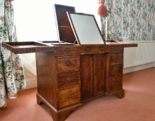 A GENTLEMAN'S MAHOGANY DRESSING TABLE with folding flaps, mirror, powder and other compartments with