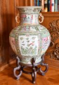 A LARGE CHINESE CANTON TWO-HANDLED BULBOUS VASE, on a wooden stand. 2ft 4ins high.