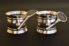 A PAIR OF NOVELTY PLATE TENNIS SERVIETTE RINGS.