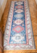 A SMALL PERSIAN RUNNER RUG with seven medallions. 8ft x 2ft 8ins.