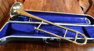 A BLESSING SCHOLASTIC BRASS TROMBONE, in a case.