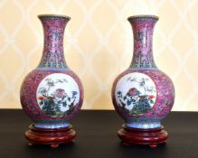 A PAIR OF CHINESE FAMILLE ROSE BULBOUS VASES with circular panels of birds and flowers. 9ins high,
