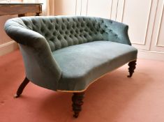 A VICTORIAN SHAPED BUTTON BACK SETTEE on turned legs and castors. 4ft 9ins long.