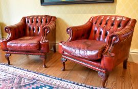 A MATCHING PAIR OF BUTTONED BACK ARMCHAIRS.