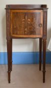 A MAHOGANY INLAID BOWFRONTED BEDSIDE TABLE on turned legs, 1ft 4ins wide, and a lamp.
