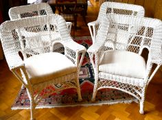 A SET OF FOUR WHITE PAINTED CANE ARMCHAIRS with loose cushions.