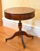 A REPRODUCTION MAHOGANY SMALL CIRCULAR TOP DRUM TABLE with two drawers, on a centre pillar and
