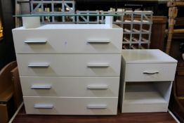 A modern white laquer four drawer bedroom chest with glass top together with a bedside chest