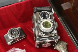 A Rolleiflex camera and a small Eljy Lumiere camera