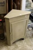 A small painted corner cupboard