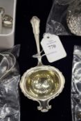 A silver tea strainer