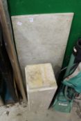 A slab of marble and a marble style pedestal stand