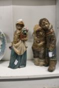 Two modern Lladro figures one of a young girl holding a plant pot the other of two eskimo children