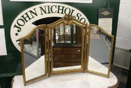 A gilt framed three fold dressing table mirror