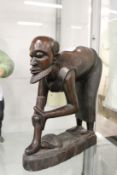 Carved hardwood African figure of a man bending forward