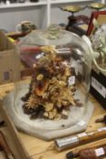 A large glass dome on an alabaster base enclosing a dried flower arrangement