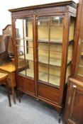 A mahogany standing two door glazed display cabinet (lacking glass one end)