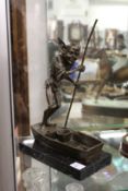 An amusing bronze of a pixie on a punt mounted on a marble base