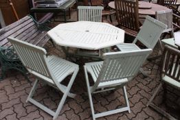 A painted octagonal shaped folding garden table and four similar chairs