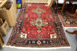 A Persian carpet red ground with two central lozenge designs