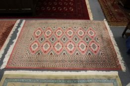 A modern pink ground Bokhara style rug