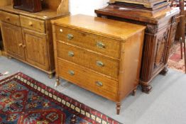 A good George III faded mahogany and satinwood banded three drawer chest with faux bamboo column