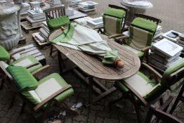 A good large patio table with parasol and six folding armchairs with cushions
