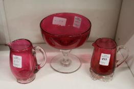 Three pieces of cranberry glassware