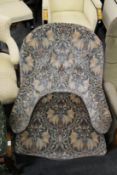 A Victorian button back armchair on turned front legs