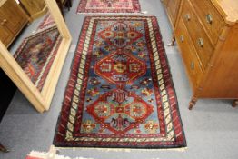 A Persian style rug pale blue ground with three central large logenze shape designs
