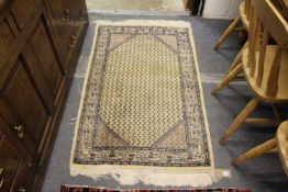 A small beige ground Persian design rug