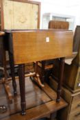 A small mahogany drop leaf table with two drawers