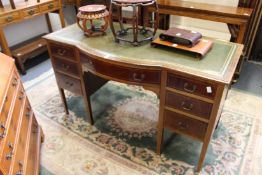 An Edwardian inlaid mahogany desk with central bow fronted drawer flanked by three drawers to each