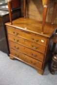 A George III mahogany small chest of drawers with brushing slide over four graduated long drawers on