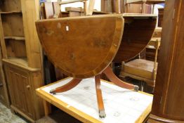 A yew wood drop leaf pedestal table