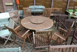 A large folding circular table with lazy susan centre piece, six folding armchairs with cushions