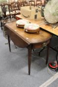 A mahogany oval pembroke table with a drawer to each end on tapering square legs