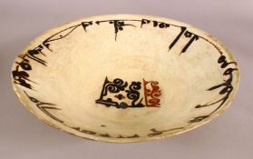 A NISHAPUR GLAZED POTTERY BOWL, the inner border with a band of Kufic script, 35cm diameter.