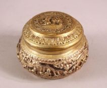 A BURMESE SILVER EMBOSSED BOX & COVER with moulded figural decoration, 11cm