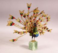 A DECORATIVE GILT METAL AND ENAMELLED MODEL OF A PEACOCK, plumage on full display, mounted on an