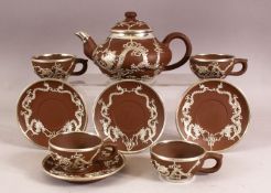A CHINESE YIXING POTTERY WHITE METAL OVERLAID TEAPOT with four matching cups and saucers, teapot: