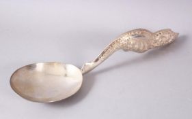 A LARGER BURMESE WHITE METAL MOULDED SERVING SPOON, the spoon with an embossed decorated floral