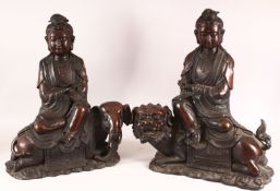 A PAIR OF CHINESE CAST BRONZE FIGURES OF GUANYIN SEATED UPON LION DOGS, Each impressed to the