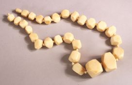 AN IVORY BEAD NECKLACE, comprising 26 facet beads, largest 33mm wide, 46cm long. Weight 108g.