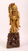 A CHINESE CARVED SOAPSTONE FIGURE - SHOU LAO - the figure of the immortal stood holding a staff