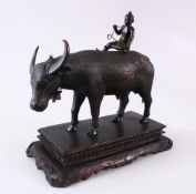 AN INDIAN JAIPUR SCHOOL BRONZE MODEL OF A COW, with a boy seated upon its back