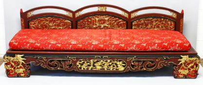 AN IMPRESSIVE CHINESE CARVED GILDED AND RED LACQUERED SETTEE, the triple humped back with gilded